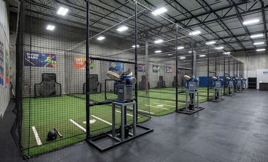 Indoor batting cage facility with netted lanes and pitching machines, representing batting cage costs and profitability.