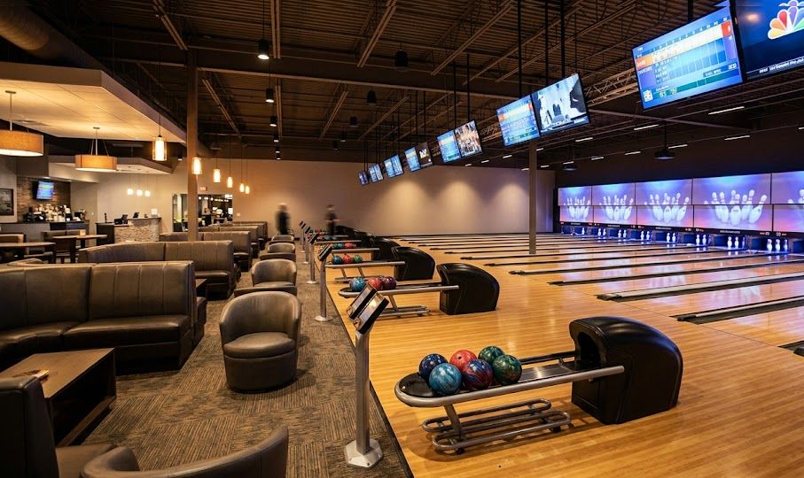 Interior of a bowling alley with polished lanes and seating, representing bowling alley startup costs.